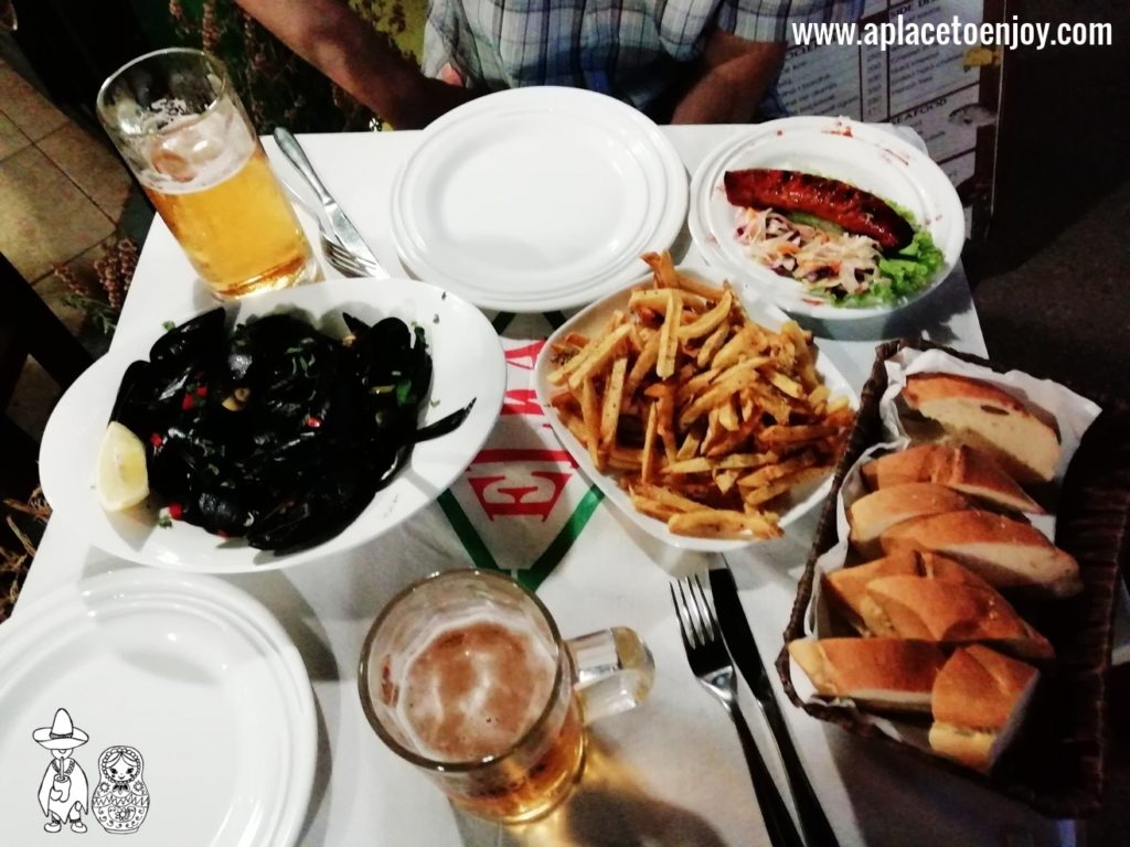 Shelled mussels, a grilled sausage with french fries and beer